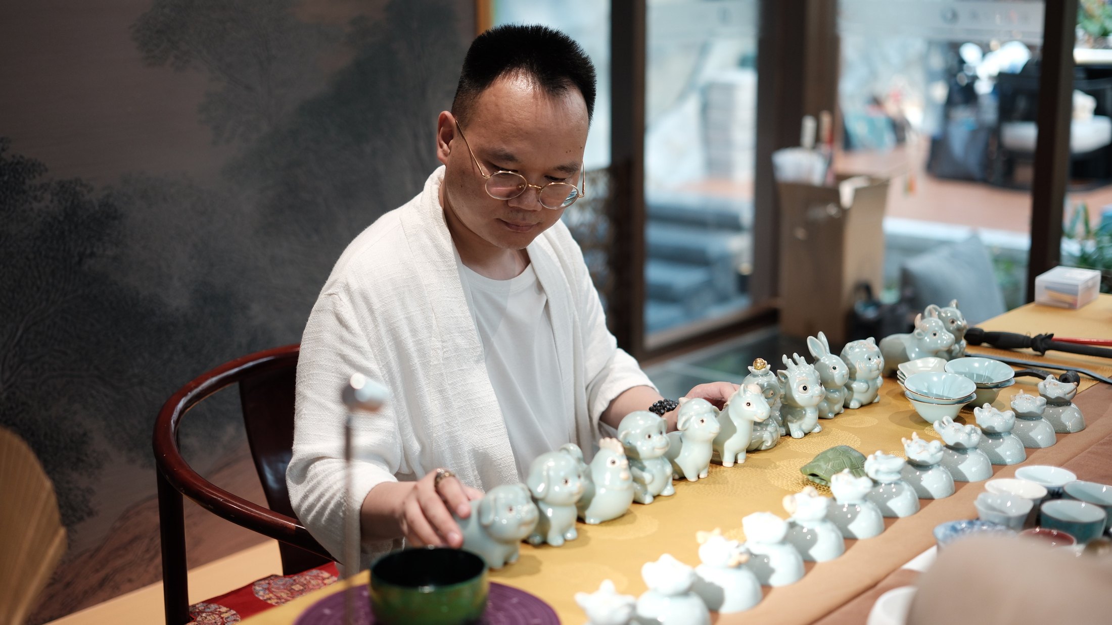 Cultural host presenting a collection of Chinese zodiac porcelain pieces in Beijing