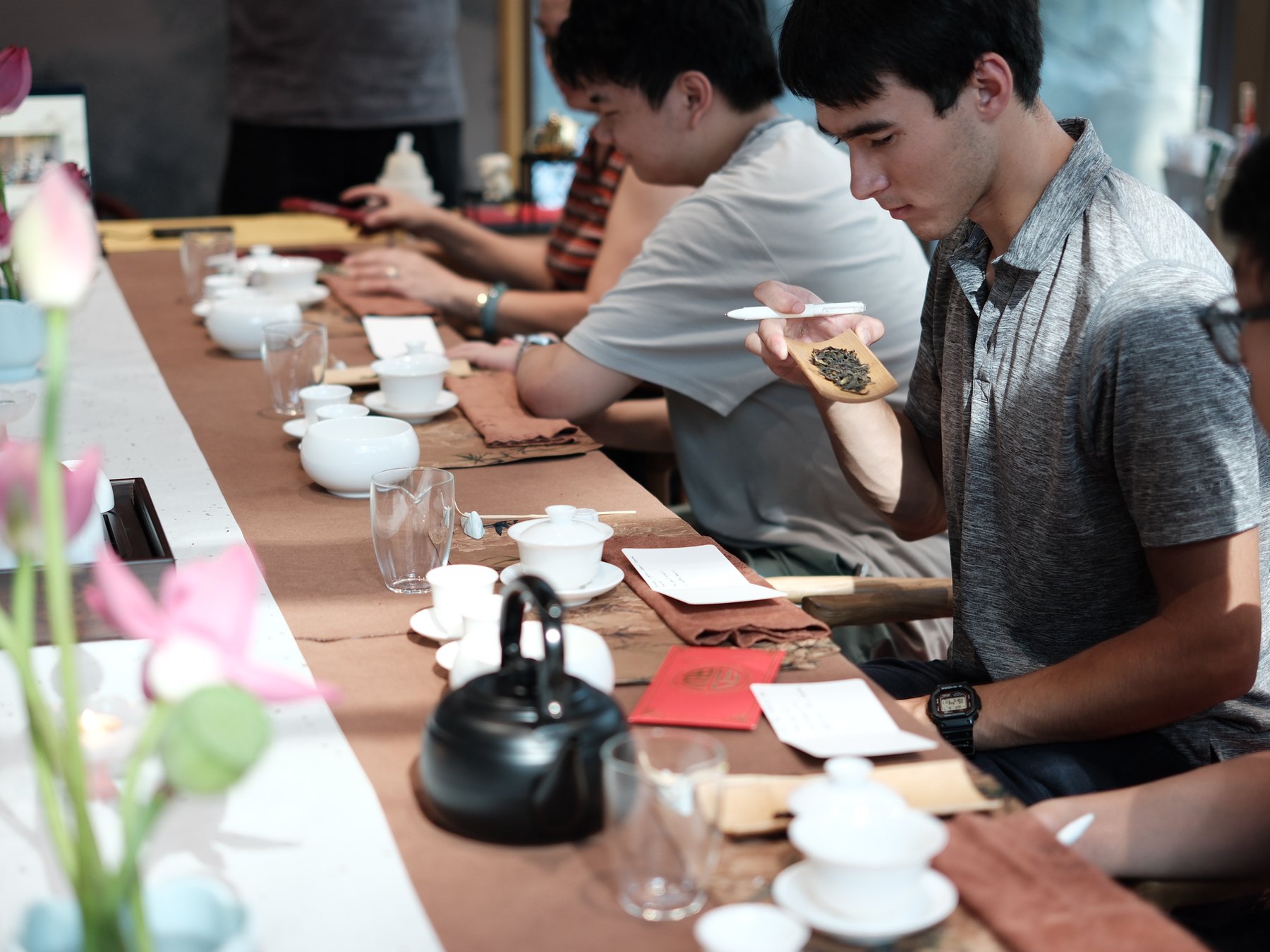 Guest observing the aroma and appearance of a mystery Chinese tea
