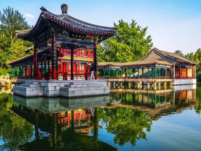 Traditional pavilion and covered walkway beside water in the Grand View Garden area