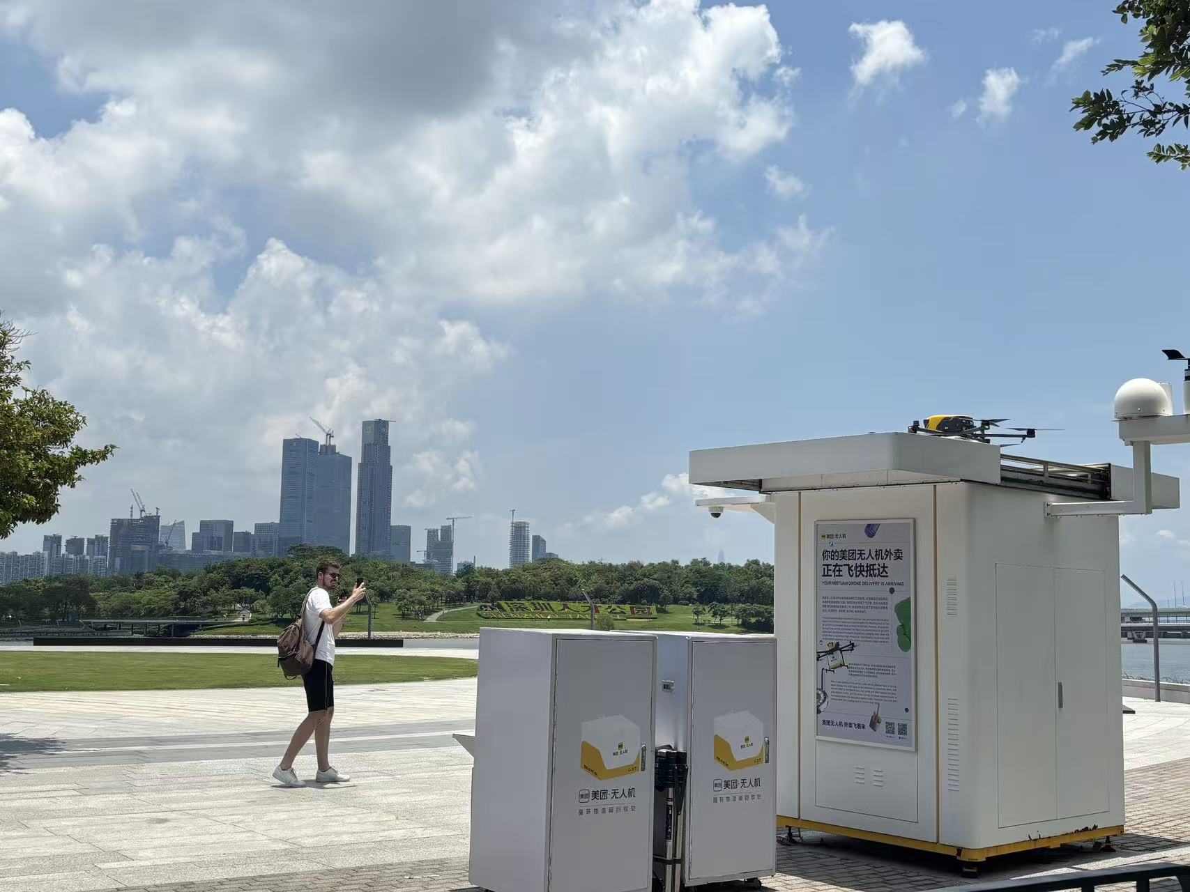 A visitor photographing a drone delivery station in a Shenzhen park
