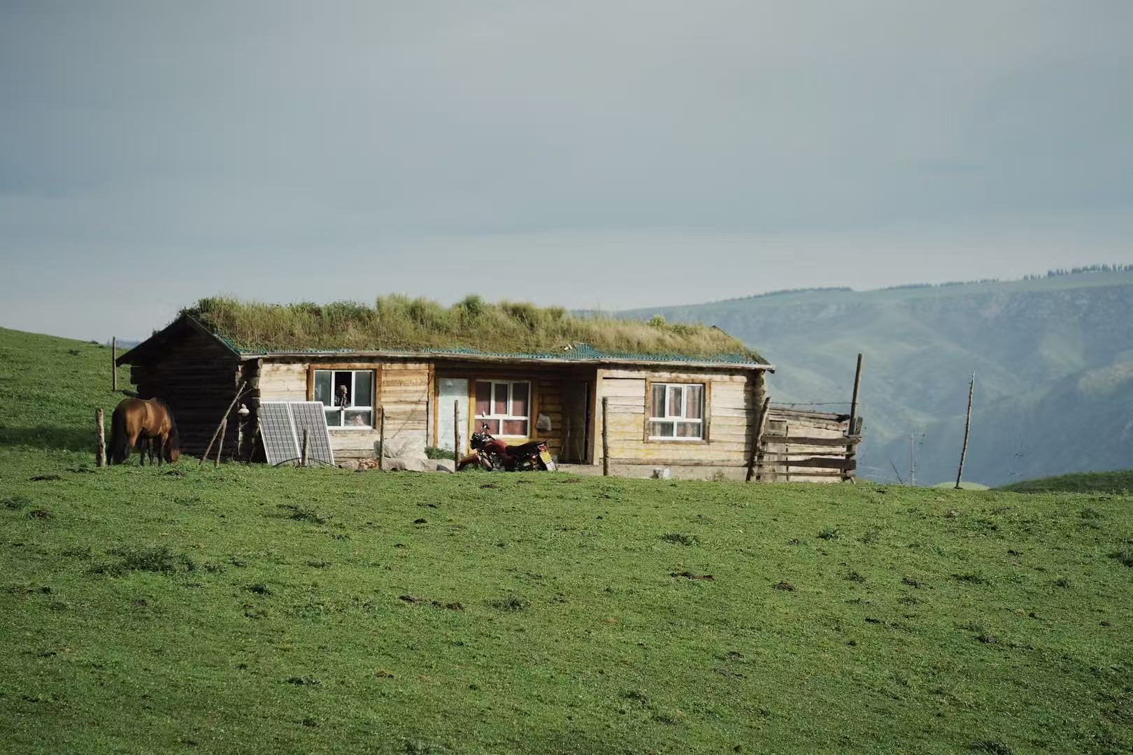 Grassland cabin and mountain landscape in western China